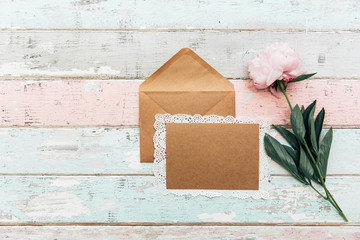 Wall Mural - Beautiful pink peony,card with envelope on vintage background. Top view, flat lay. Invitation greetings concept