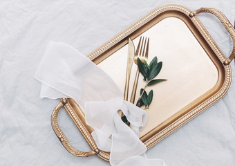 Wall Mural - Gold cutlery on tray. Festive Place Setting