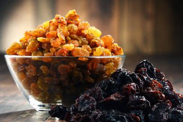 Canvas Print - Composition with bowl of raisins on wooden table