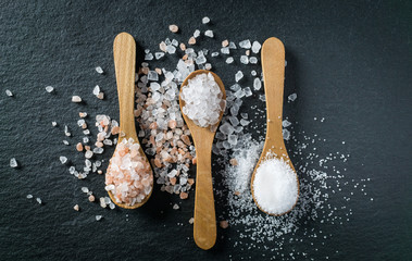 Different types of salt. Top view on three wooden spoons