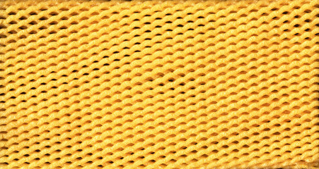Yellow EPE fruit net abstract close-up background. Expanded polyethylene foam net macro texture