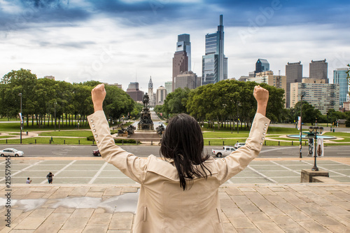 Photo  A young business woman flexing and imitating the famous Rocky pose as a symbol o