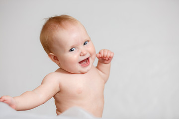 A Baby girl in white bedding at home look nice