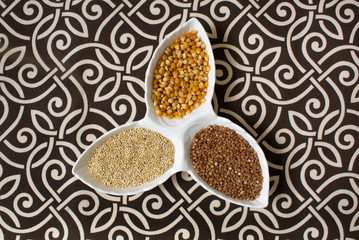 Various cereals, cereals. Different types of cereals in bowls on a patterned, black and white background. Buckwheat, corn, chenopodiumum quinoa. Healthy eating.