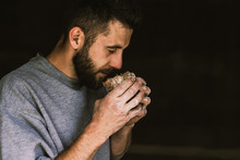 Close Up Of A Young Bearded Man Smelling Delicious Freshly Baked Bread