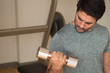 © 9nong - fitness man working out in gym; portrait of asian man doing weight training with dumbbell in fitness gym; asian north indian adult man model