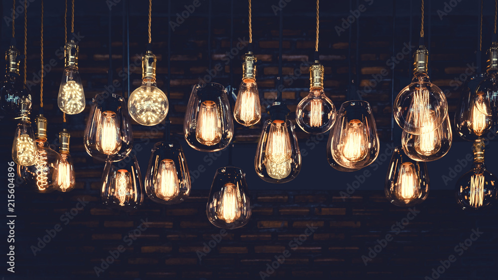 Beautiful vintage luxury light bulb hanging decor glowing in dark. Retro filter effect style. - obrazy, fototapety, plakaty 