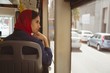 © Wavebreak Media - Young woman looking through window while travelling in bus