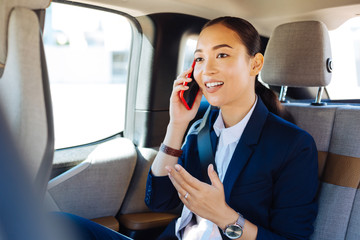 Wall Mural - Money talk. Nice smart businesswoman having a phone conversation while sitting in her car