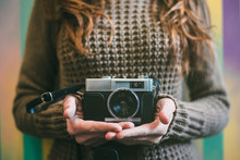 Happy Young Woman Holding A Vintage Camera In A Colorful Background
