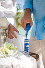 Close Up Of A Wedding Couple Hand Mixing White And Blue Sand Ceremonies, The Groom And The Bride Pour Sand On The Wedding Ceremony.
