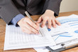 © kasinv - business man analyzing graph and chart document report