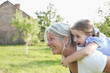 © suzanam - Little girl on a piggy back ride with her grandmother
