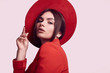 © micro - Elegant beautiful woman in a red fashionable suit and wide hat