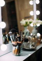 Wall Mural - Perfumery and cosmetics on a dressing table with a mirror