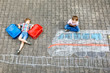 © Irina Schmidt - Two little kids boys having fun with train picture drawing with colorful chalks on ground