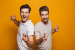 © Drobot Dean - Portrait of a two happy young men best friends pointing fingers
