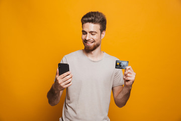 Wall Mural - Portrait of a satisfied young man using mobile phone