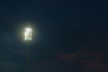 Wall Mural - Light tower reflectors at a stadium during nightime.