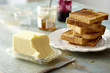 © Radius Images  - Stack of Whole Wheat Toast on Plate with Block of Butter and Jam on Tabletop