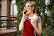 © SHOTPRIME STUDIO - woman in glasses talking on the phone in hand a cup of coffee on the street a city walk