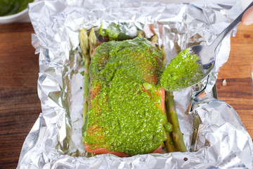 Wall Mural - Preparation of salmon with pesto, tomatoes, asparagus