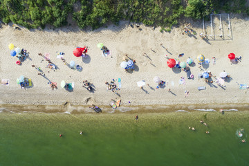 Wall Mural - three red umbrellas on the beach and people in aerial view