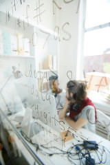 Wall Mural - Coding startup project: young programmer discussing work and using computer in background, focus on script language on glassy board