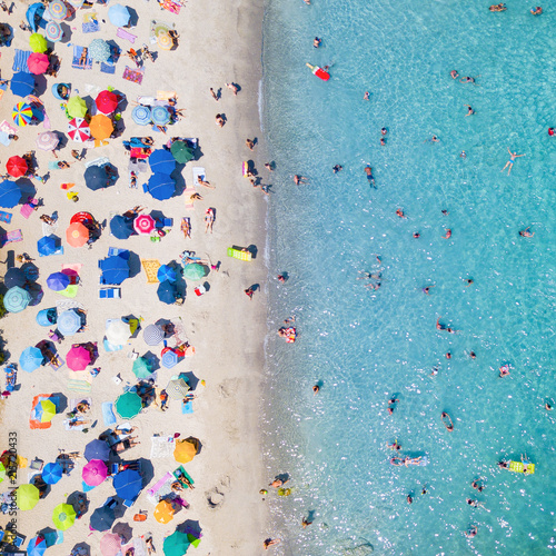 Fotografia  View from above, aerial view of an emerald and transparent Mediterranean sea with a white beach full of beach umbrellas and tourists who relax and swim