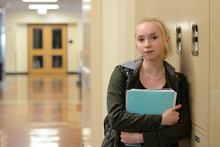 High School Student In Hallway With Notebook