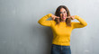 © Krakenimages.com - Middle age hispanic woman over grey wall wearing glasses smiling confident showing and pointing with fingers teeth and mouth. Health concept.