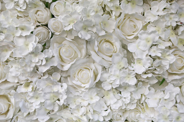 Artificial white rose and flowers background.