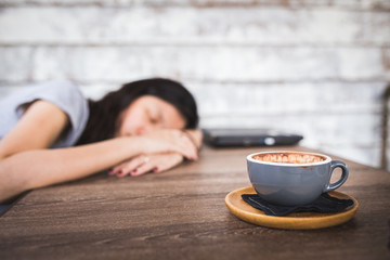 sleeping woman behind coffee drink