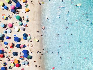 Wall Mural - View from above, aerial view of an emerald and transparent Mediterranean sea with a white beach full of beach umbrellas and tourists who relax and swim. Costa Smeralda, Sardinia, Italy.