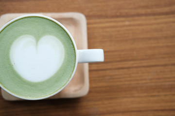 Wall Mural - hot matcha green tea with heart latte art on wood table