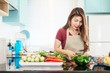 © pairhandmade - Young lady in modern bright kitchen prepare food with colorful vegetable - people and home doing cooking activity concept