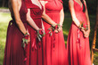 Flower bracelets with red roses and silk ribbons. Bridesmaids in red dresses, american style wedding