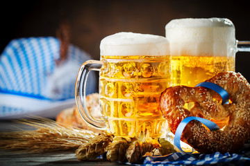 Wall Mural - Beer mugs and pretzels on a wooden table. Oktoberfest. Beer festival.