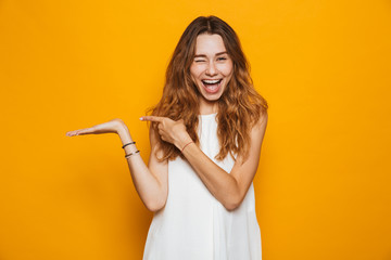 Poster - Portrait of a cheerful young girl pointing away