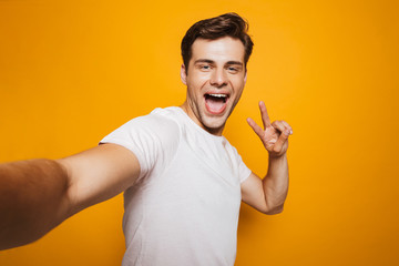 Poster - Portrait of a happy young man taking a selfie