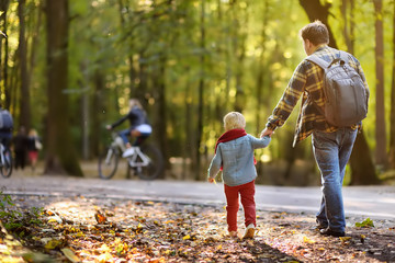 Father and his little son during the hiking activities in forest at sunset