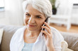 © Syda Productions - technology, communication and people concept - close up of happy senior woman calling on smartphone at home