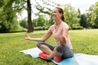 © Syda Productions - fitness, yoga and healthy lifestyle concept - happy woman meditating in summer park