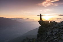 Young Man Standing On The Top Of The Mountain And Enjoying Total Freedom During Sunset In South Tyrol
