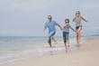 © altanaka - Father and children  playing on the beach at the day time.