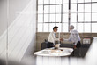 © Monkey Business - Two businessmen seen through window shaking hands in office