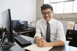 © Monkey Business - Young Asian male professional at desk smiling to camera