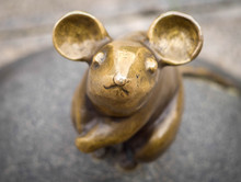 A Close-up Of The Sculpture Of The Mouse With Large Ears (sculptors S.Plotnikov And S.Yurkus) Performing Desires On The Cobbled Street Of The Old Town Of Klaipeda, Lithuania