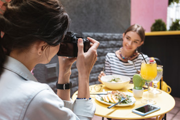 Wall Mural - Photo of woman. Professional photographer wearing jeans jacket making photo of beautiful woman