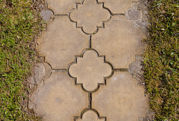 Close up brick pathway edge with green grass lawn